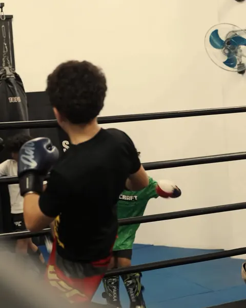 Un enfant, gants aux poings, sur le ring de la salle